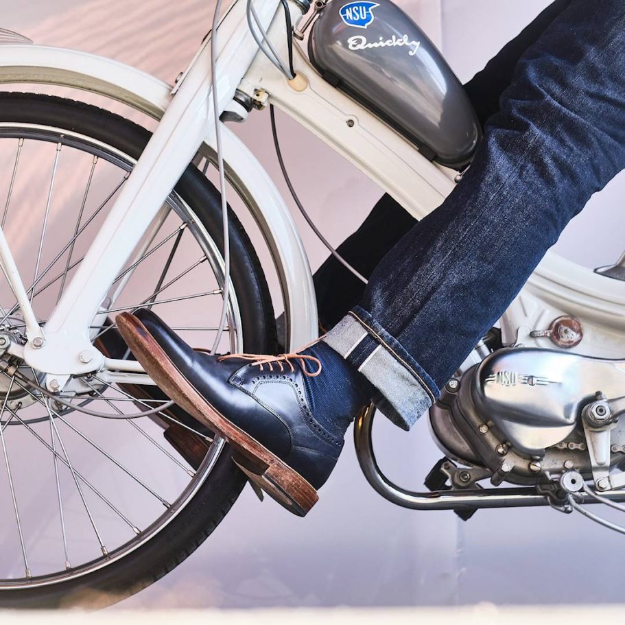 Ein Fuß in einem eleganten Schuh auf einem Fahrradpedal.